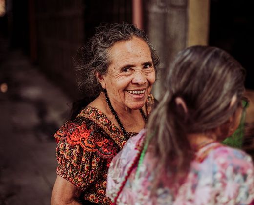 Senhoras em trajes tradicionais em roda de conversa