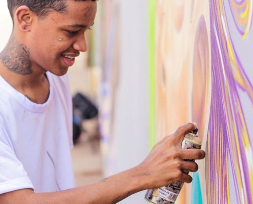 Artista pintando um grafite colorido no muro