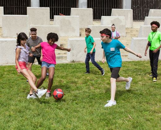Crianças brincando de futebol no pátio da escola