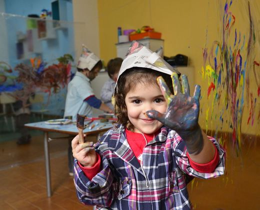 Criança animada em atividade de artes na sala de aula