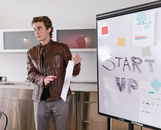 Jovem apresentando ideia de negócio em quadro branco