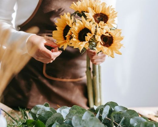 Mãos entregando um buquê de flores artesanal
