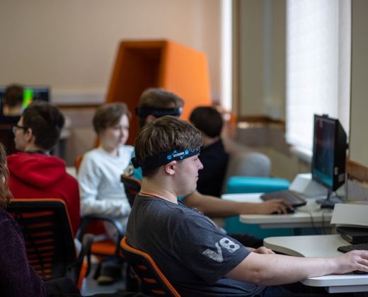Jovens estudando programação em laboratório de informática