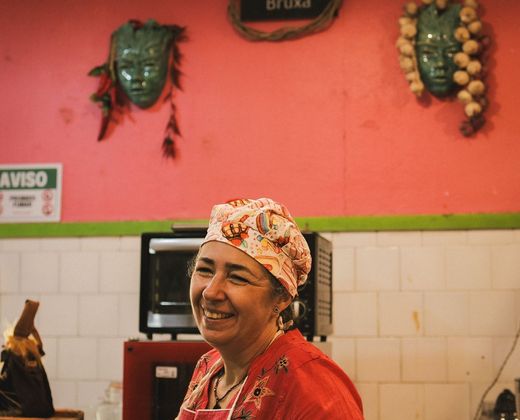Vendedora sorridente em seu ponto no mercado