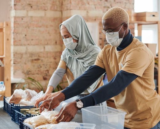Voluntários preparando e servindo refeições solidárias