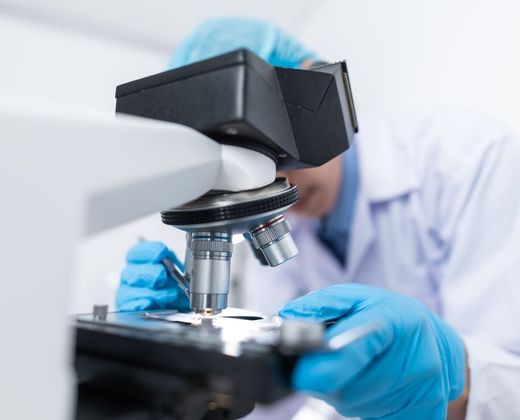 Pesquisador analisando amostra em microscópio