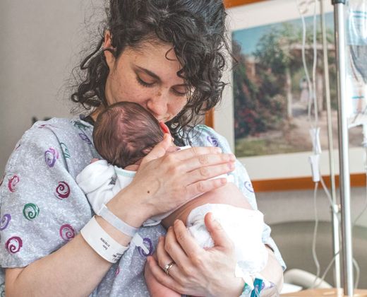 Mãe com o recém-nascido no quarto da maternidade