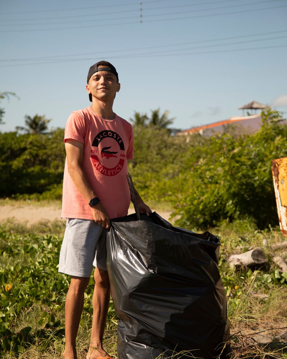 Jovem recolhendo resíduos em área verde