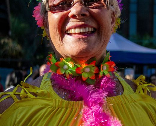Mulher sorridente em festa popular, com adornos coloridos
