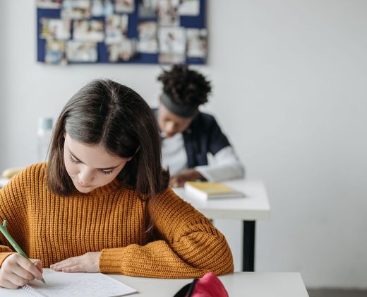 Meninas estudando juntas em sala de aula