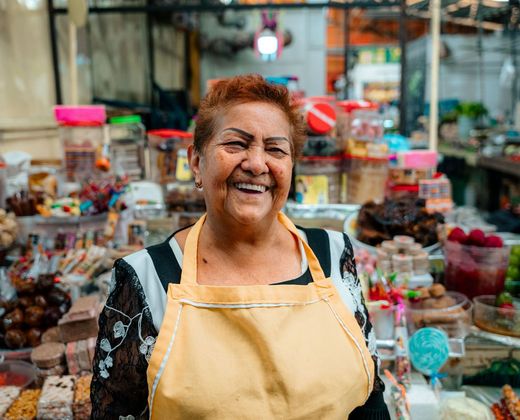 Mulher sorridente em seu ponto de venda no mercado