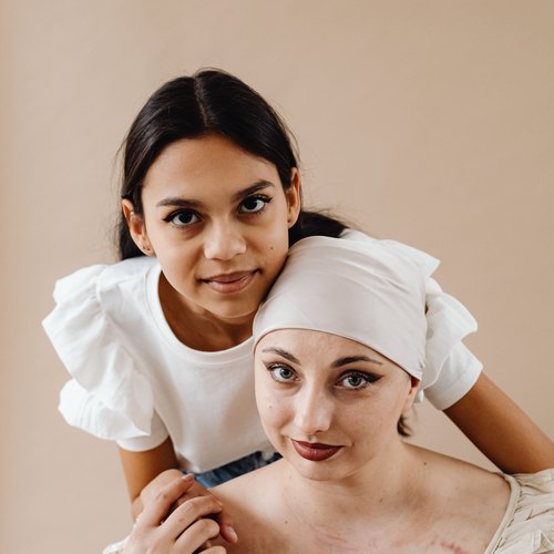 Jovem em tratamento sendo maquiada por uma amiga